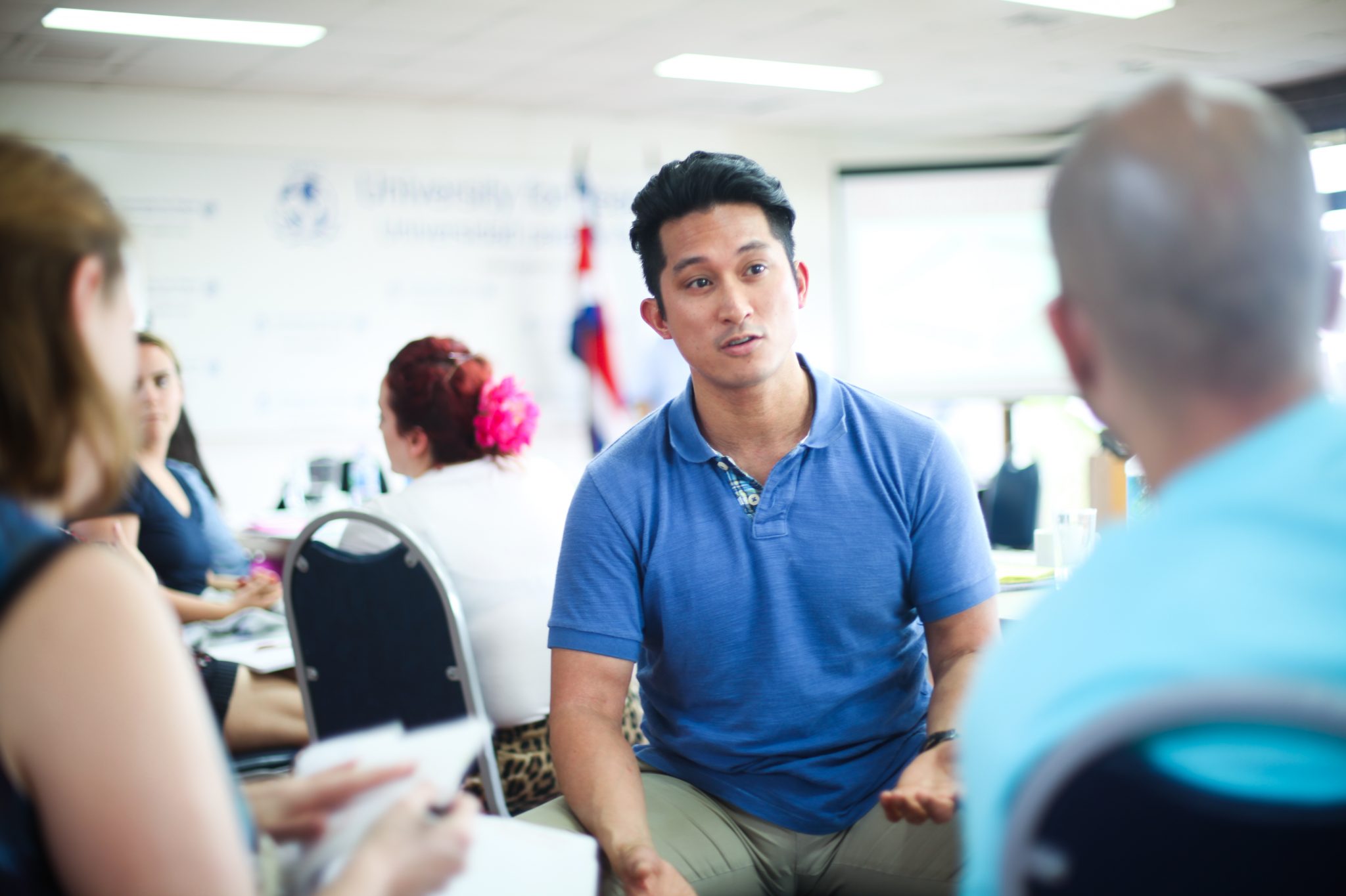 Participant in a blue shirt during a Workplace Insight course discussion
